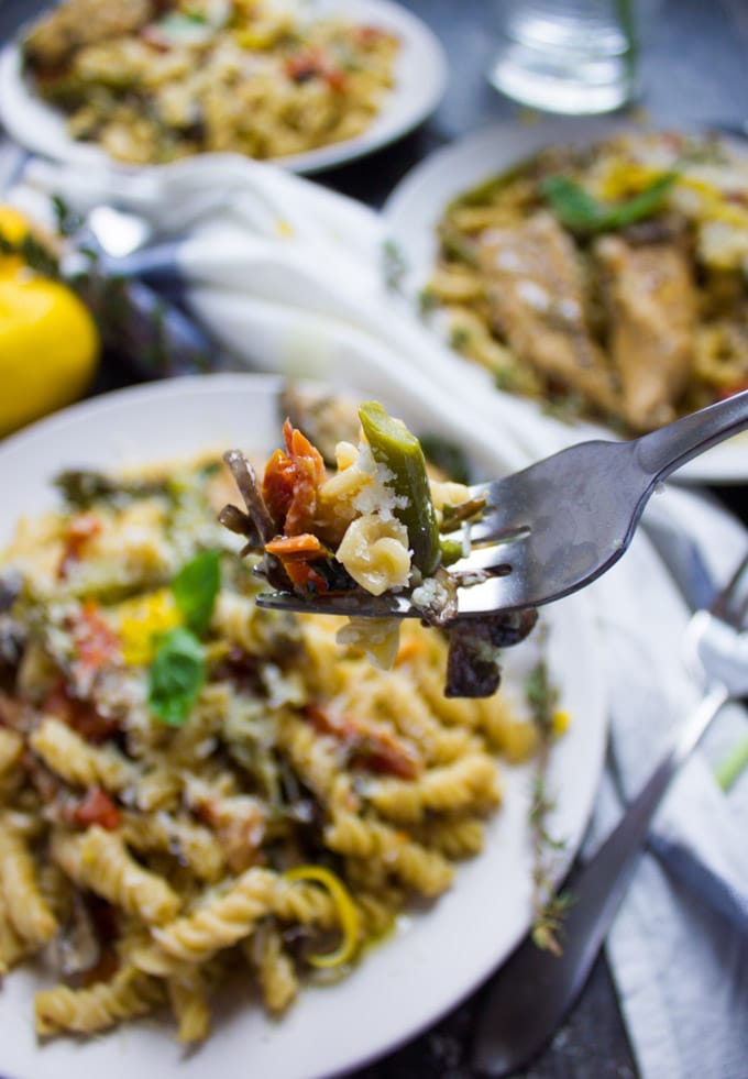 a fork full of creamy chicken pasta over a plate of Fusilli pasta