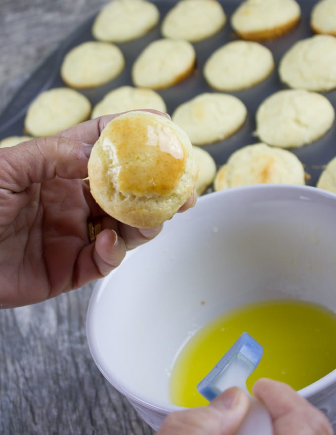 brushing the top of the mini muffin donuts with butter.