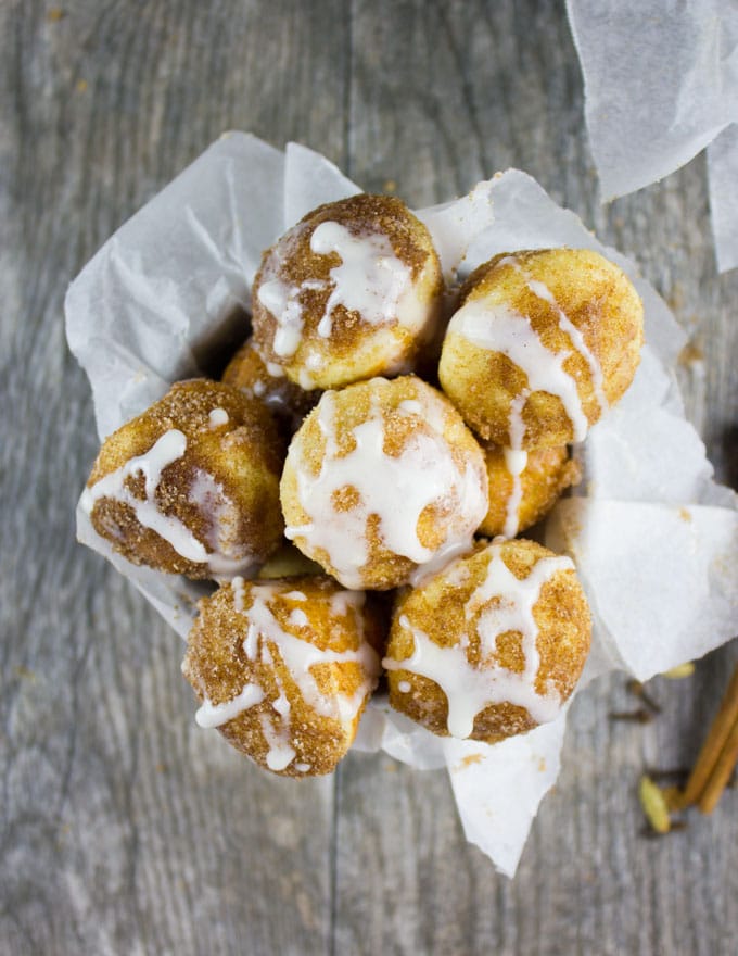 overhead shot of a cup filled with Baked Donut Holes with Cinnamon Sugar and Vanilla Glaze