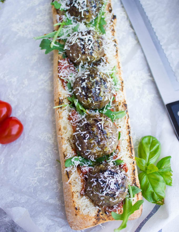 overhead shot of an open-faced American Lamb Meatball Sub with marinara sauce and parmesan