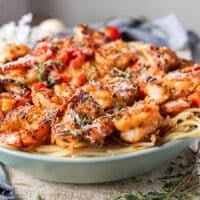 side view of shrimp pasta showing the layers of pasta and mediterranean style shrimp on top
