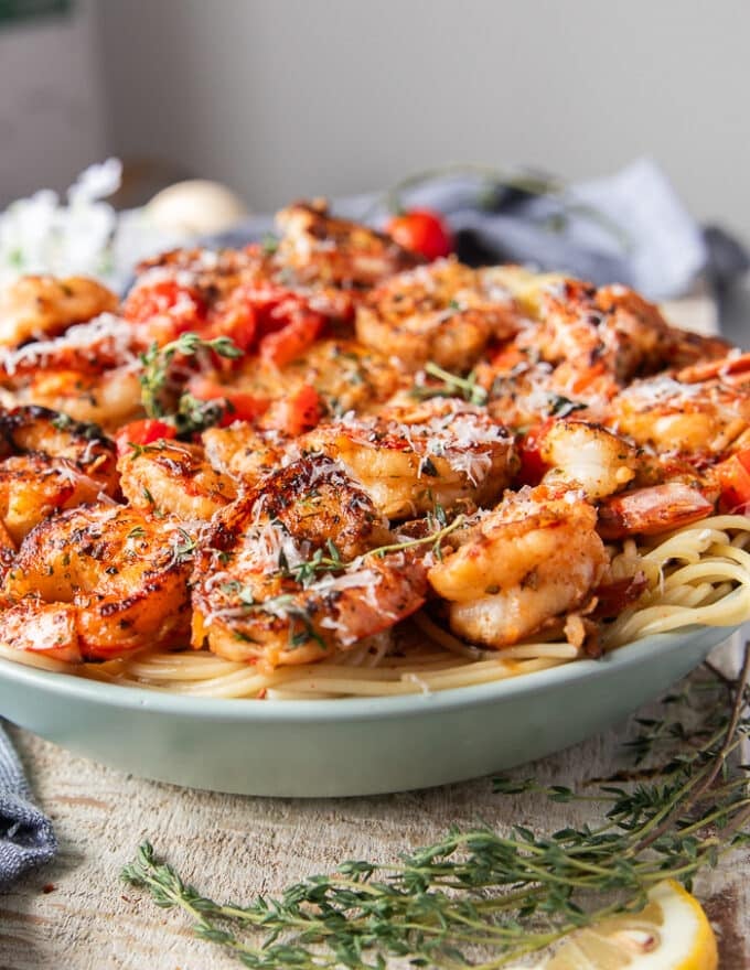 side view of shrimp pasta showing the layers of pasta and mediterranean style shrimp on top