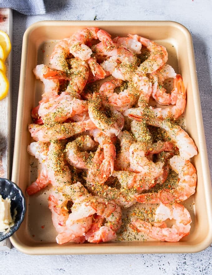 The shrimp is added to a sheet and tossed with the seasoning