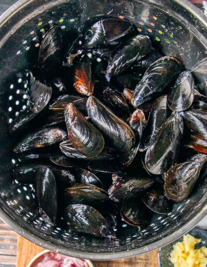 mussels rinsing in a colander