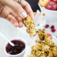 a hand holding a granola coated baked apple fry