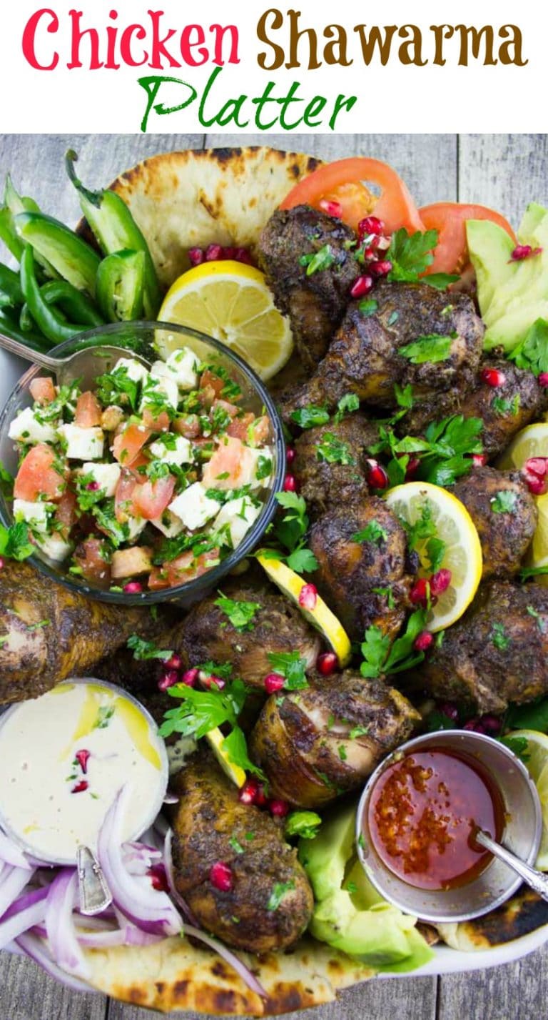 Chicken Shawarma Platter | A Middle Eastern feast of spiced Chicken Shawarma drizzled with a creamy Tahini Sauce, a zesty and spicy Harissa Sauce - all served on oven-warm naan bread together with a refreshing tomato feta salad. This is the perfect food for sharing with a group of friends or with family! #bbq, #healthy, #easy, #dinner, #party, #tahini, #shawarma, #spicy,