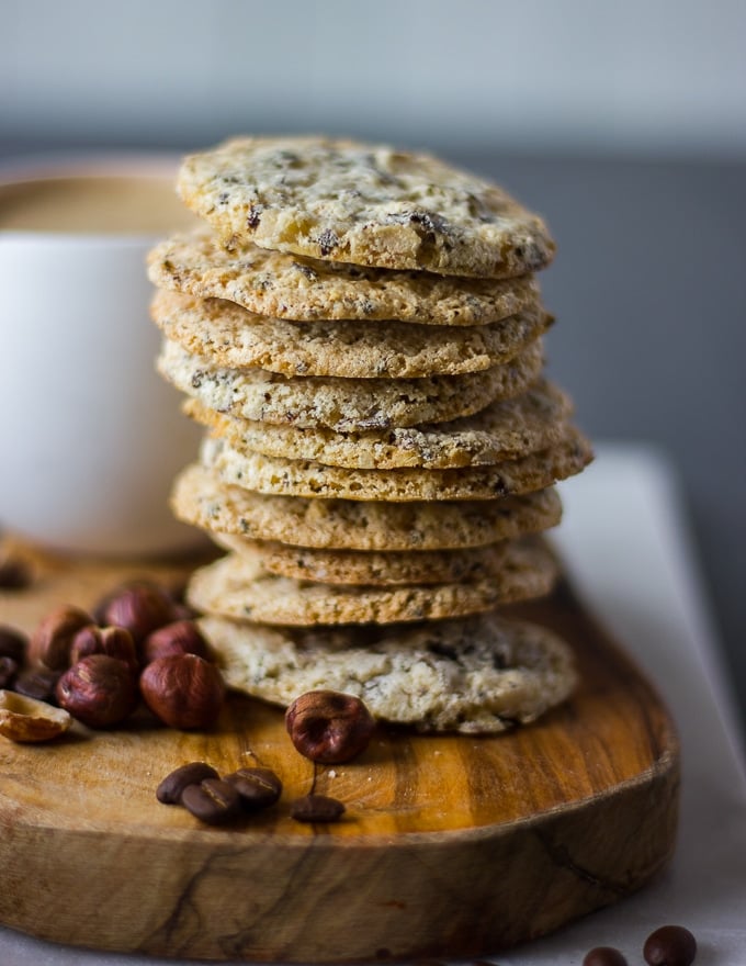 stacks of thin coffee cookies close up surrounded by coffee beans