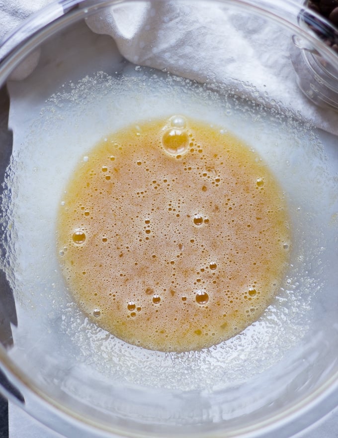 A bowl with eggs and sugar whisked together to make the chewy coffee cookies