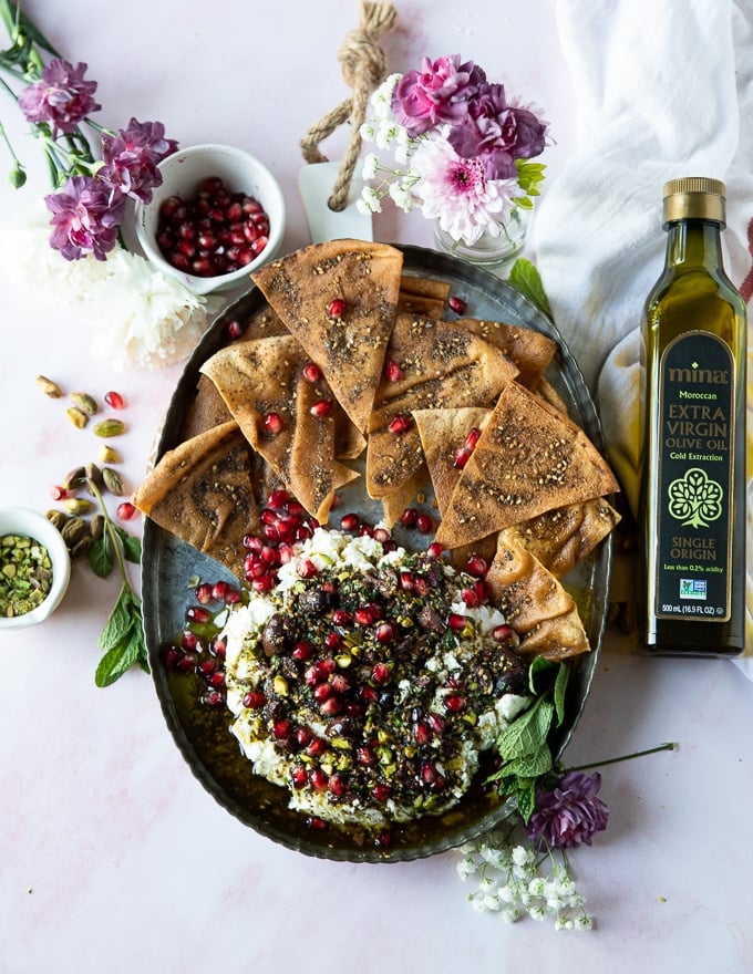 A top view of a full labneh dip platter with zaatar pita chips