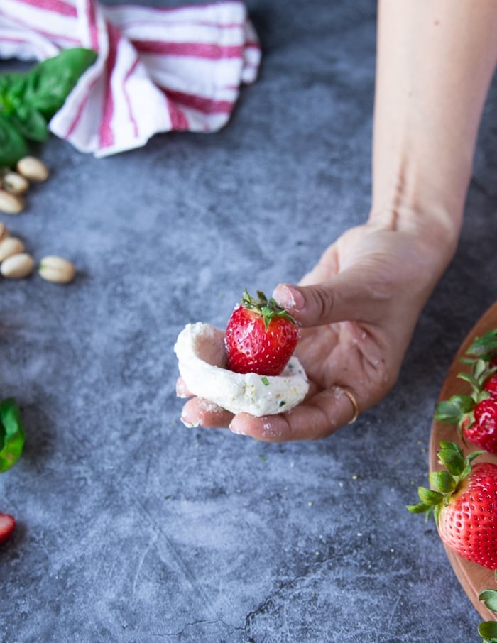 Place the strawberry in the center of the goat cheese