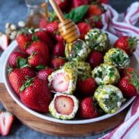 sliced up strawberries with goat cheese showing the inside texture and a honey drizzle over the top