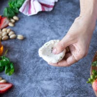 a hand making a dent in the goat cheese