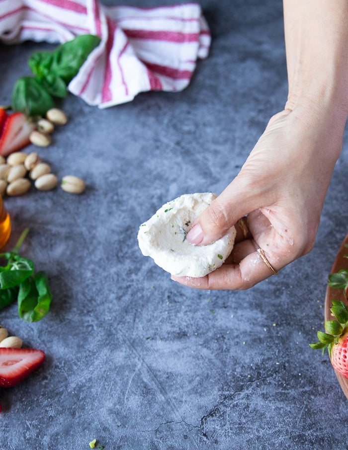 a hand making a dent in the goat cheese