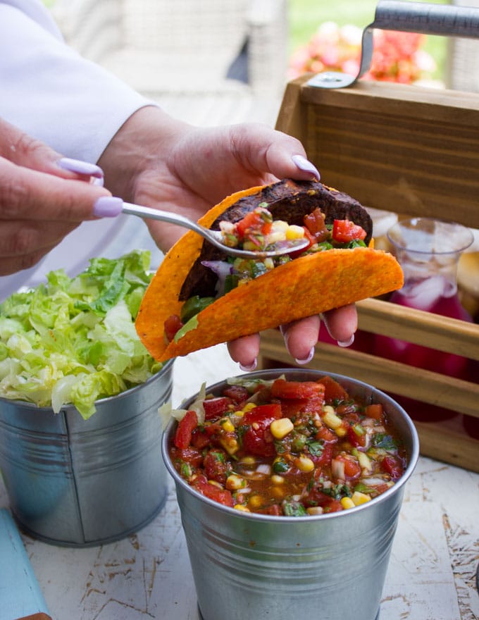 Adding some salsa over the burger in the taco shell