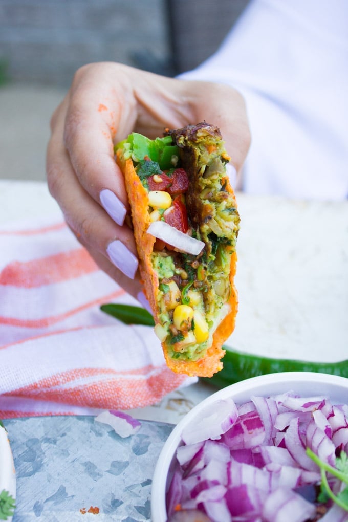 hand holding a burger taco that's bitten and showing the inside close up view