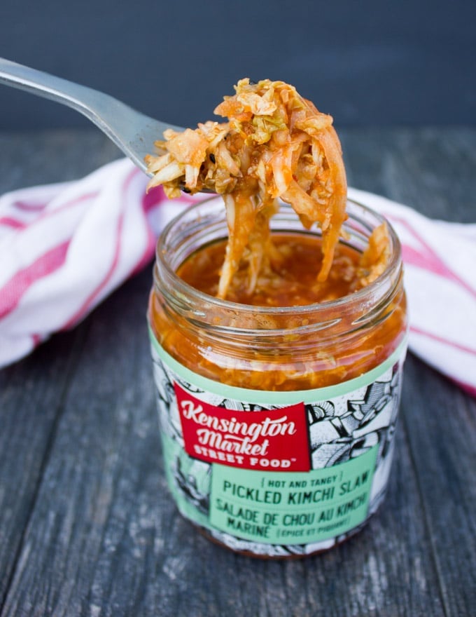 an opened jar of kimchi slaw with a fork pulling some out of the jar