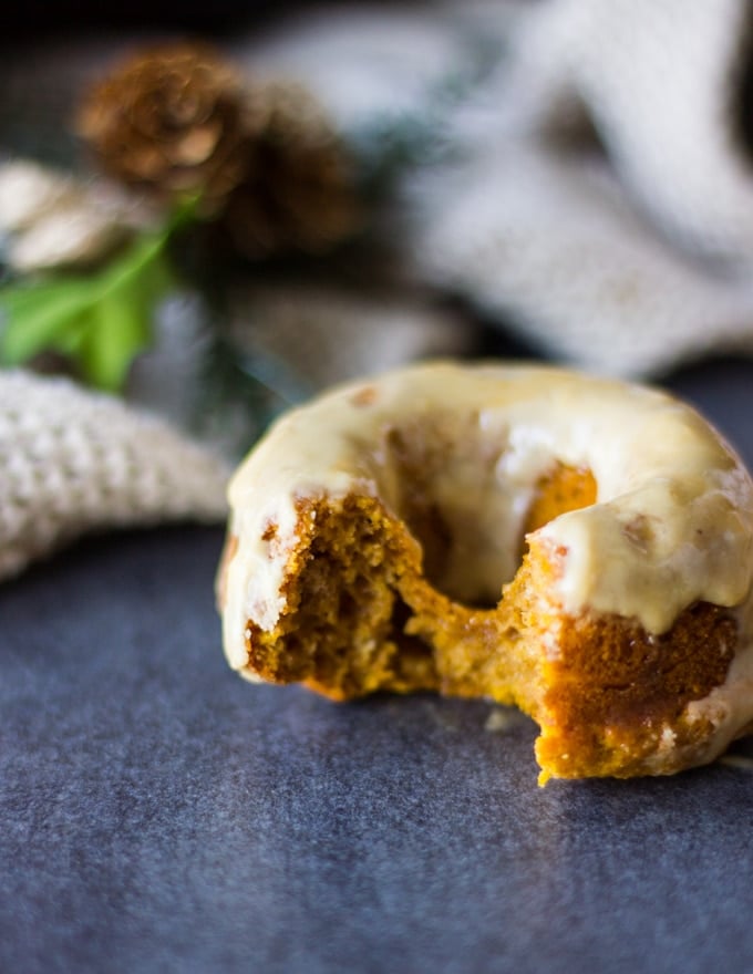 Close up of a bitten pumpkin donut showing the fluffy texture inside