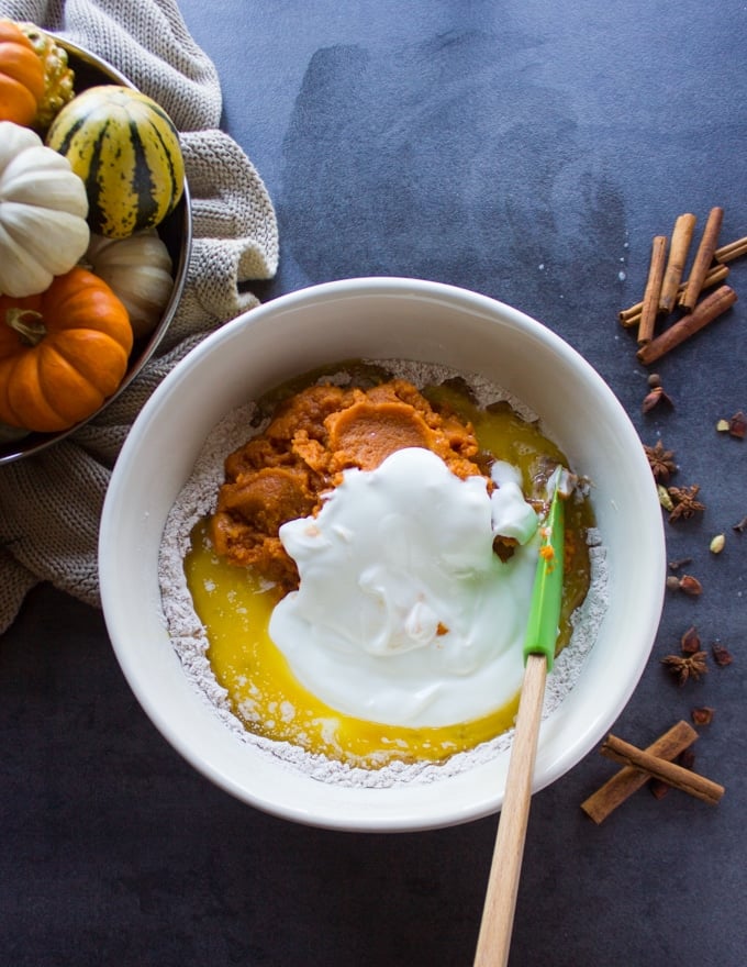 All ingredients in a large bowl with a spatula ready to mix the batter for the baked donuts
