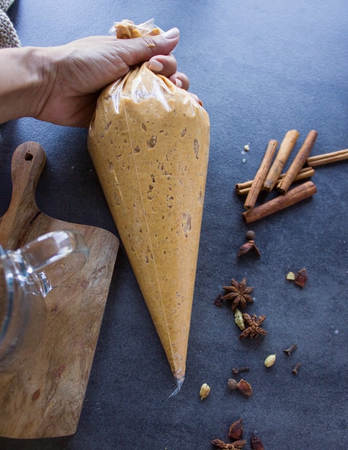 pumpkin donut batter in a piping bag