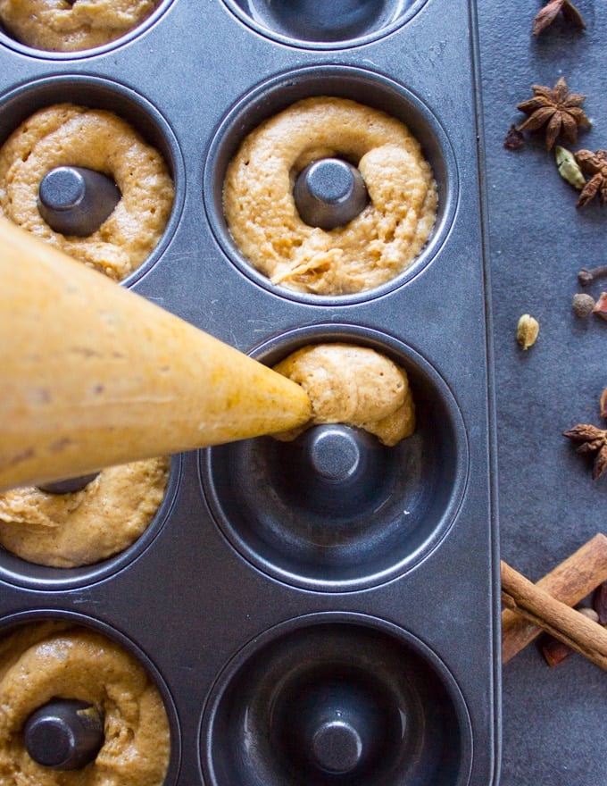 A bag piping the pumpkin donut batter into a donut pan