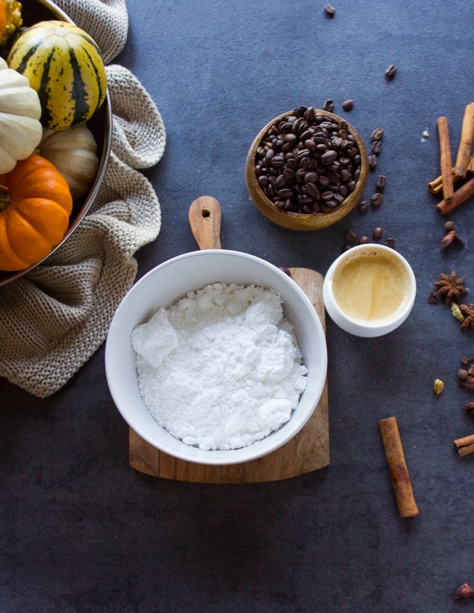 ingredients for the espresso glaze, a bowl of confectioner sugar, some brewed espresso and a whisk