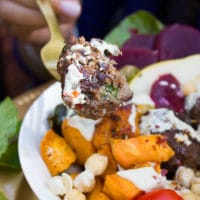 A fork holding a bitten piece of lamb meatball