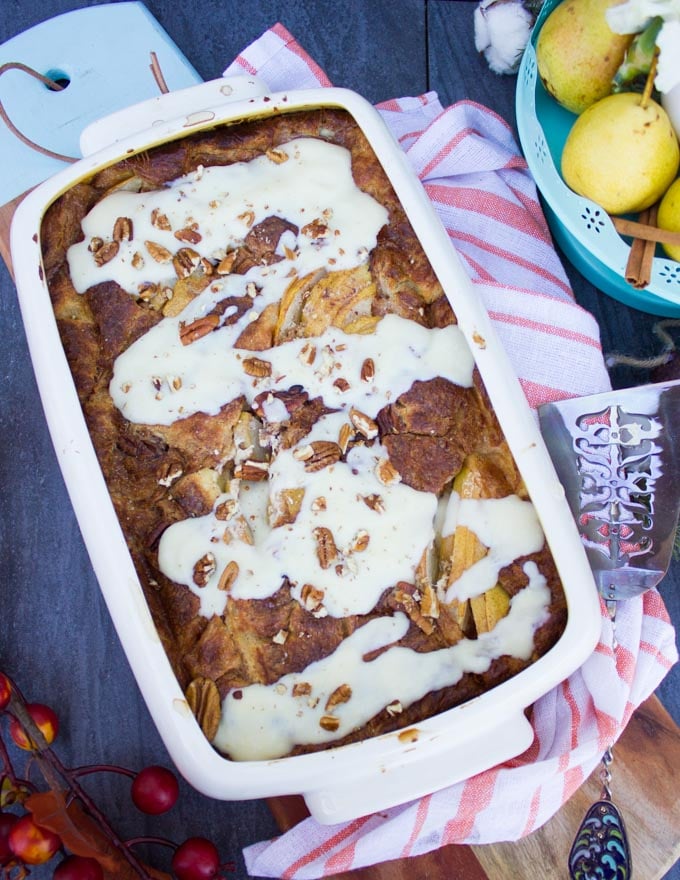 Dish of croissant bread pudding right out of the oven and drizzled with creme anglaise