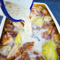 pouring a cinnamon custard over the croissant cubes and sliced pears