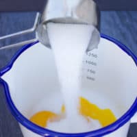sugar poured over the egg yolks in a small pot