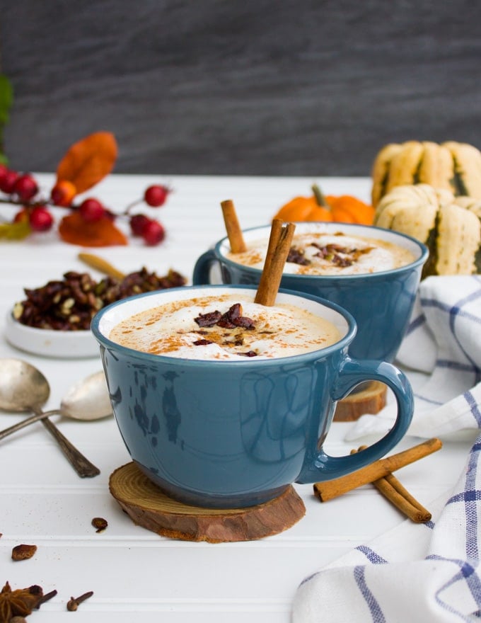 A close up cup of pumpkin spice oatmeal latte and a spoon