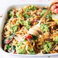 A fork pulling the broccoli pesto pasta stretching and showing the beautiful dish
