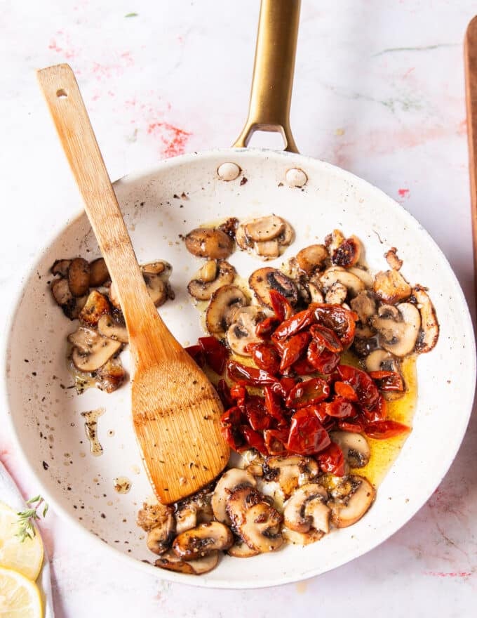 mushrooms golden in the sauce pan and the sun dried tomato is added