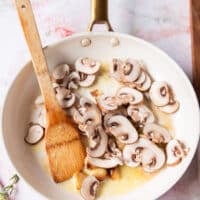 garlic and mushrooms sautéing in a sauce pan to make the pasta sauce