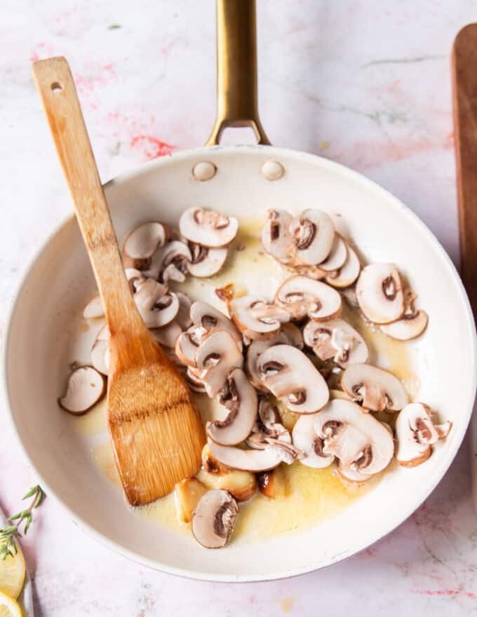 garlic and mushrooms sautéing in a sauce pan to make the pasta sauce