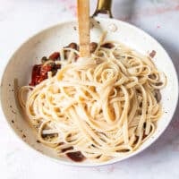 The cooked pasta and pasta water is added to the sauce pan