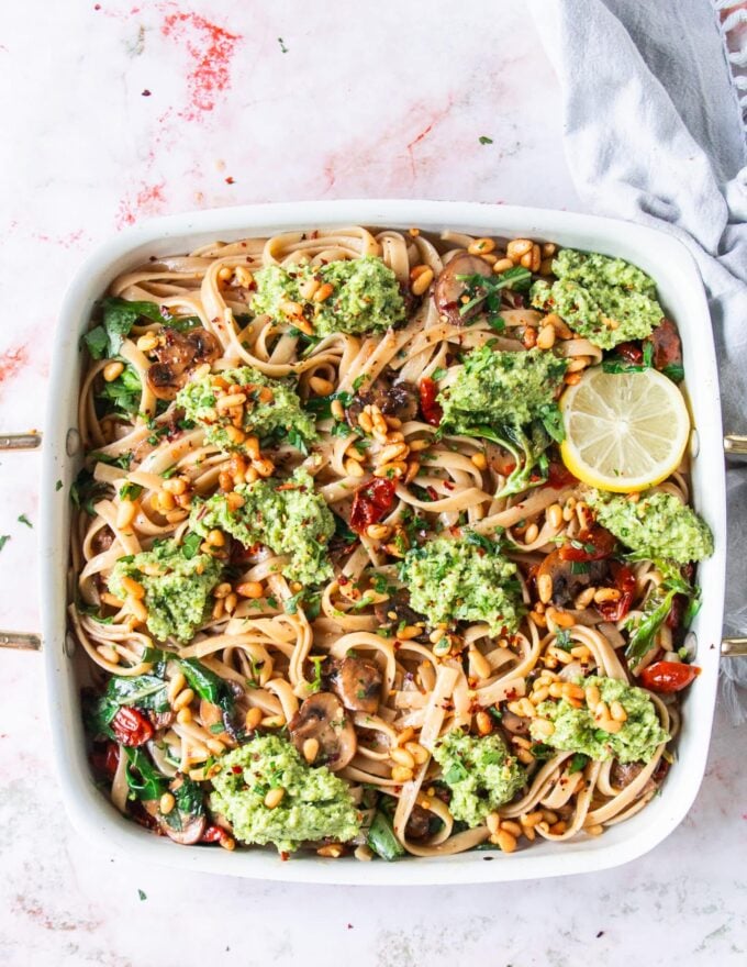 close up of broccoli pesto dolloped over the pasta