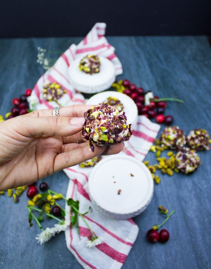 A hand holding a single mini cheesecake bite close up