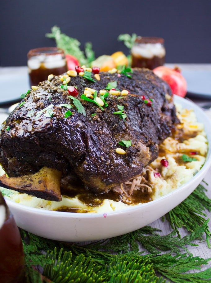 Fall off the bone tender leg of lamb recipe up close showing the bone and the mashed potatoes underneath