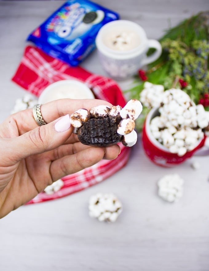 A hand holding a bitten OREO cookie ball.