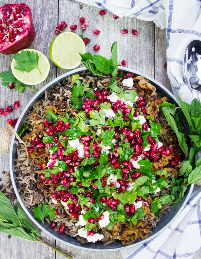 A top view of a plate of lentils and rice cooked mujadara recipe with crispy fried onions and herbs