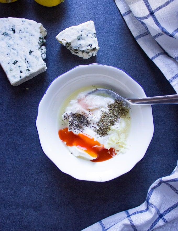 A bowl with blue cheese dressing ingredients not mixed up.