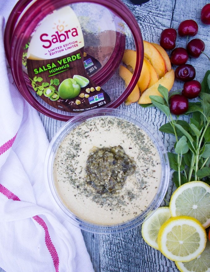 A box of opened Sabra Hummus showing the texture of the hummus and the salsa verde