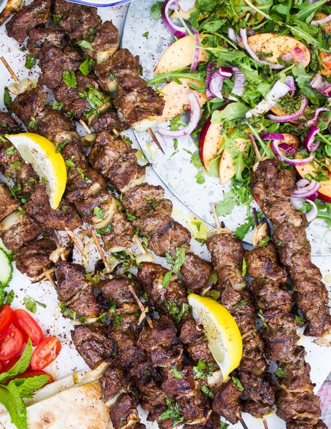 Close up of the grilled lamb skewers with lemon wedges