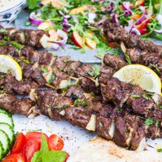 Side view of one grilled lamb skewer