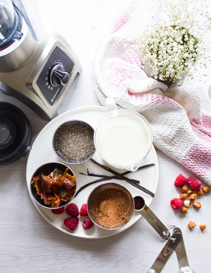 Ingredients for chia seed pudding: chia seeds, dates, milk, vanilla and cocoa powder and a blender