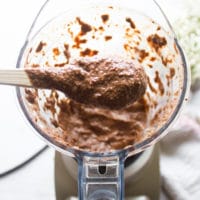 Ingredients for chia seed pudding in a blender and a spoon showing the texture