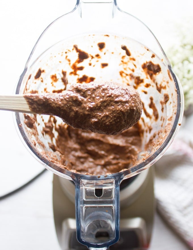 Ingredients for chia seed pudding in a blender and a spoon showing the texture