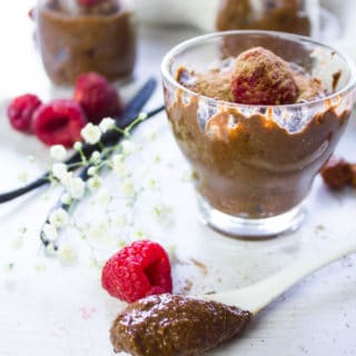 A spoon with chocolate chia seed pudding scooped and put on a board to show the texture of the pudding