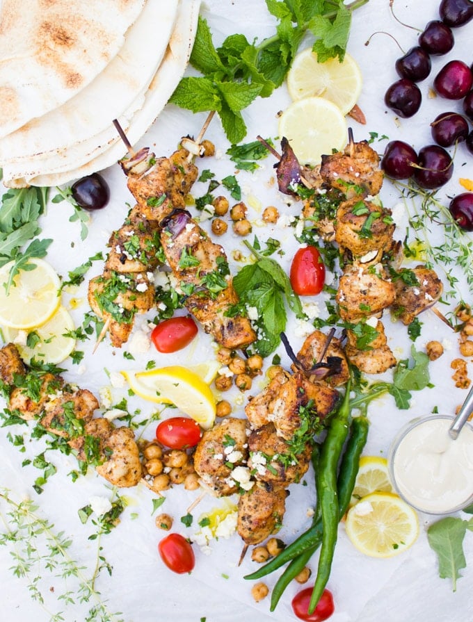 Grilled Chicken Skewers with spicy chickpeas, lemon wedges, feta crumbles, pita bread and tahini sauce.