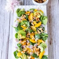 Top view of a large plate of an orange salad with orange dressing